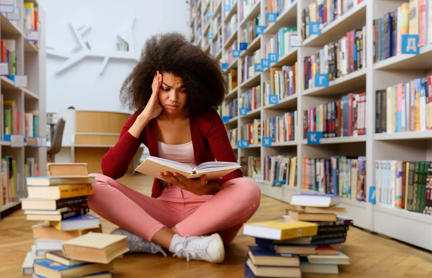 Woman seated in library, experiencing exam stress