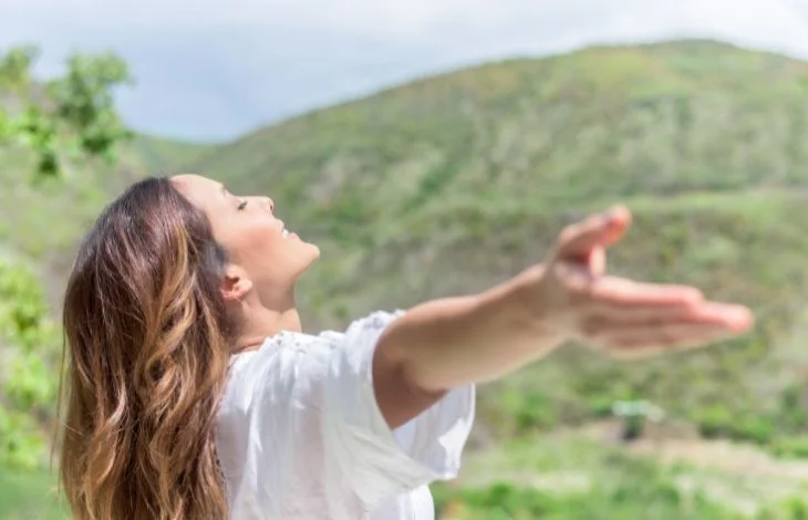 Woman standing looking grateful being free from resentment