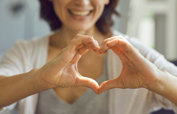 Woman making hands into heart shape