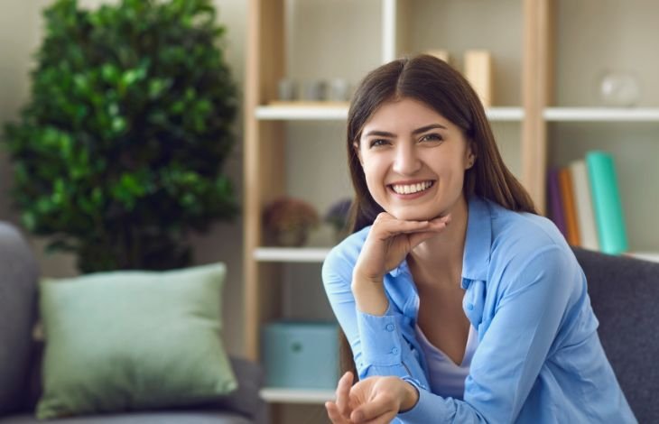 woman sitting on a couch looking happy