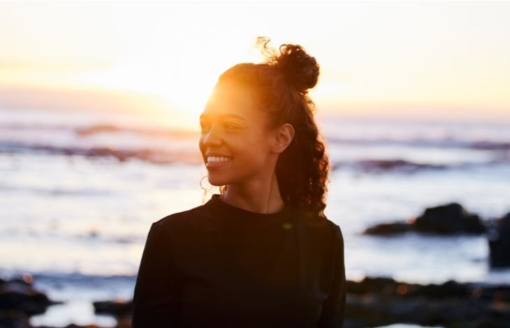 Woman looking happy in fron of the ocean