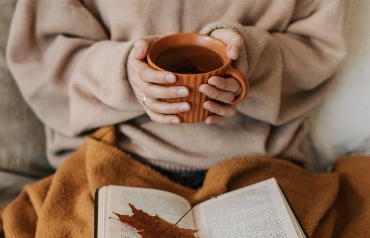 Woman with depleted mother syndrom spending time with herself drinking tea and reading